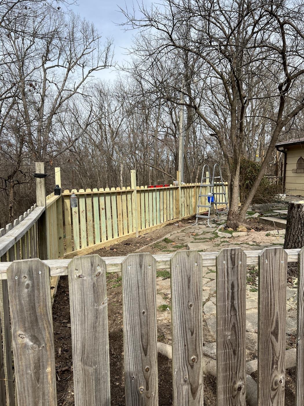 New wooden privacy fence installed around a backyard
